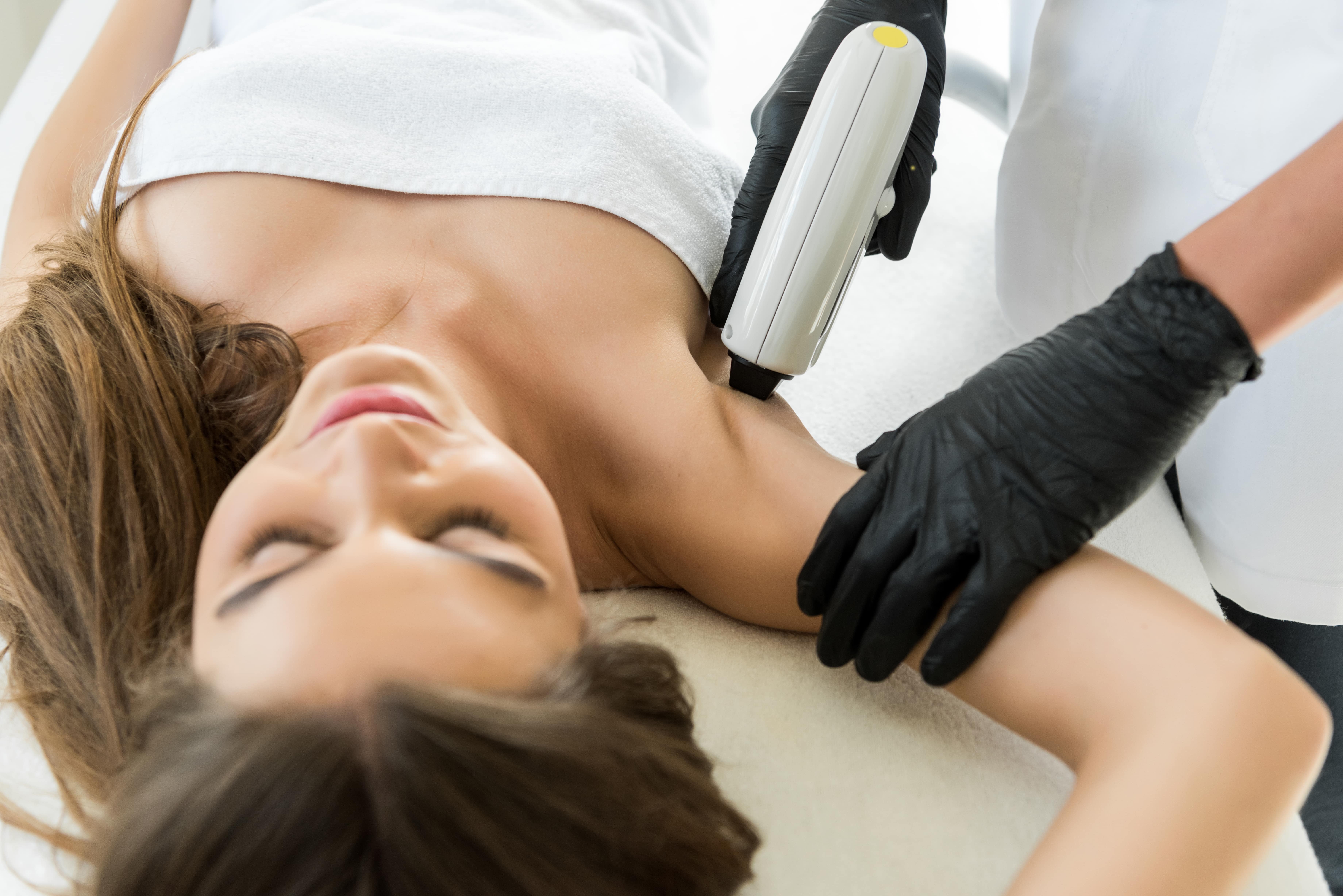 A woman is receiving a laser hair removal treatment