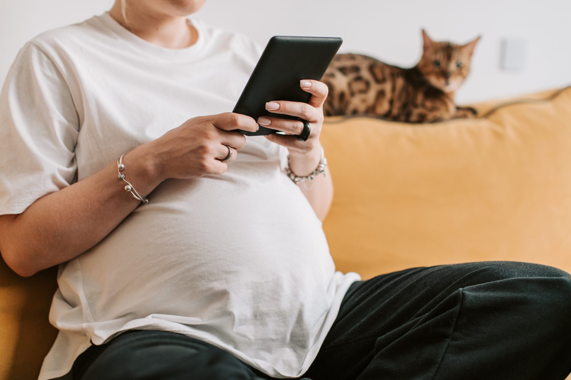 pregnant woman in white shirt holding a tablet